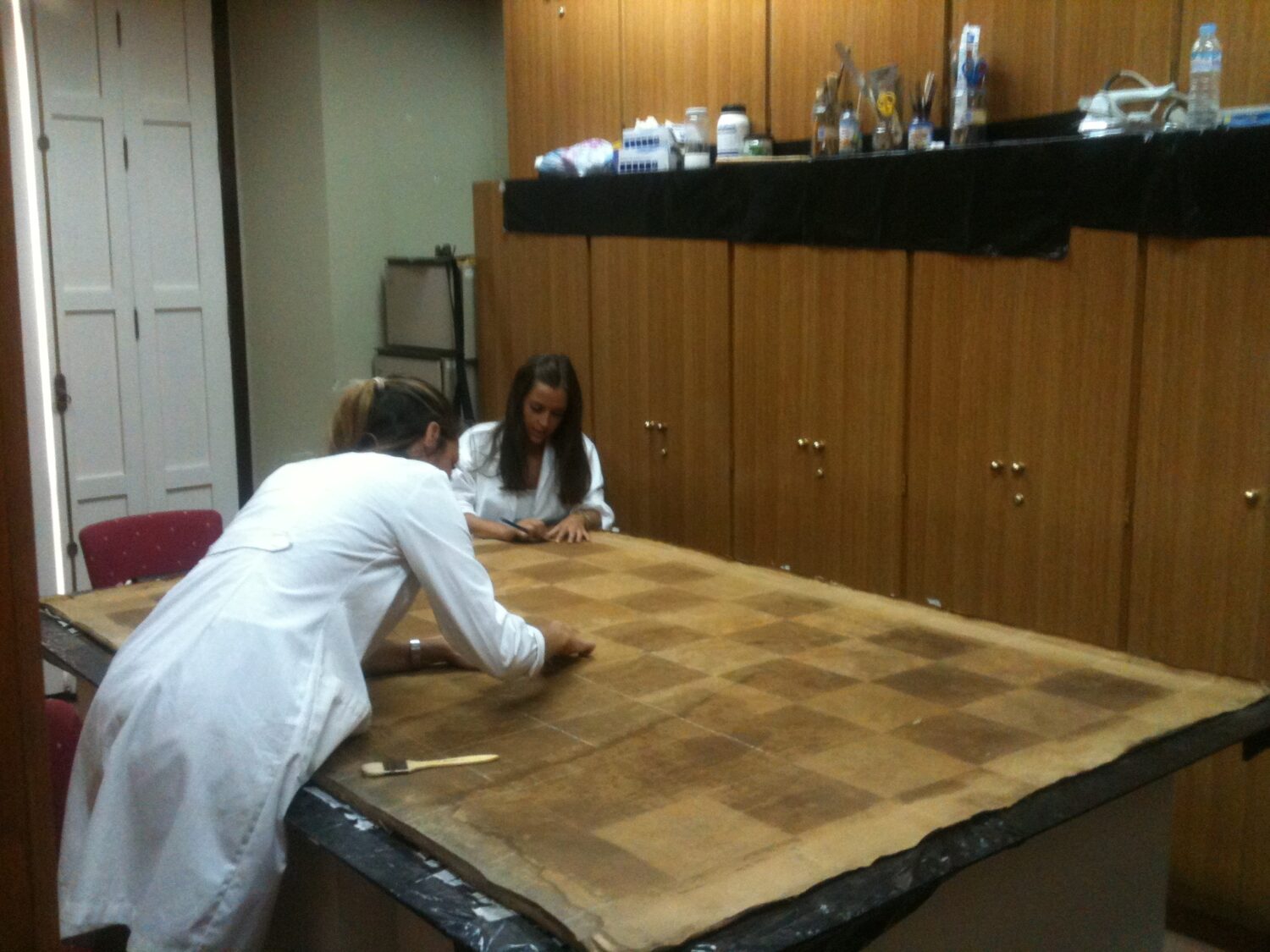 Las licenciadas en Bellas Artes, Belén Robles y Mónica Alcudia, restaurando el cuadro