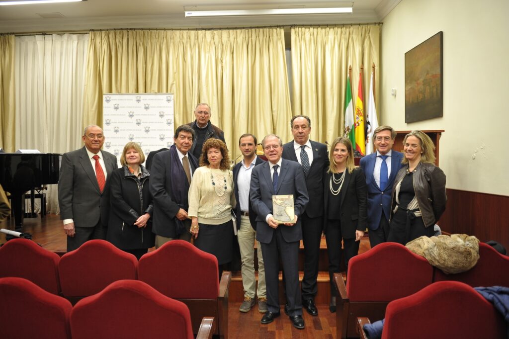 En el centro, el presidente del Ateneo, Alberto M. Pérez Calero con el libro "En busca de las especias, La primera vuelta al mundo" del que es autor, Francisco Pacheco, presidente de la Fundación Puerta de América (quien en la foto está a la izquierda de